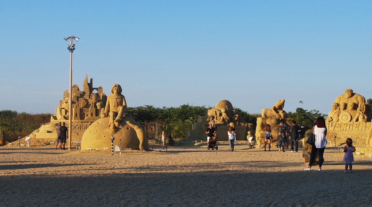 Visitors exploring sand sculptures at the Burgas Sand Festival.