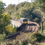 Passenger train crossing a railway viaduct in Cornwall surrounded by countryside