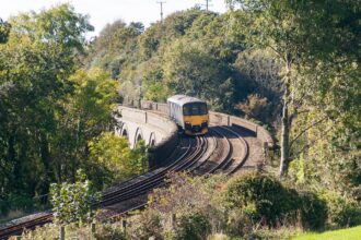 Passenger train crossing a railway viaduct in Cornwall surrounded by countryside