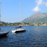 Sailing boats on Lake Lecco with the surrounding mountains, a popular day trip from Bergamo.