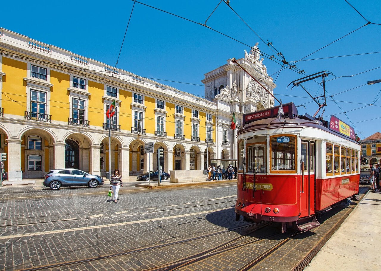 Historic Lisbon tram passing Praça do Comércio in central Lisbon, Portugal.