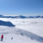 Skiers above the clouds in the Three Valleys region