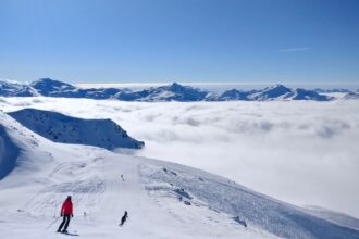 Skiers above the clouds in the Three Valleys region