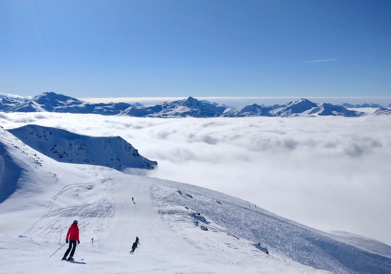 Skiers above the clouds in the Three Valleys region
