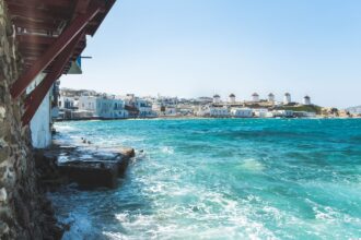 View across the waterfront towards the famous windmills of Mykonos, Greece, featured in the Mykonos Airport Transfers Guide.