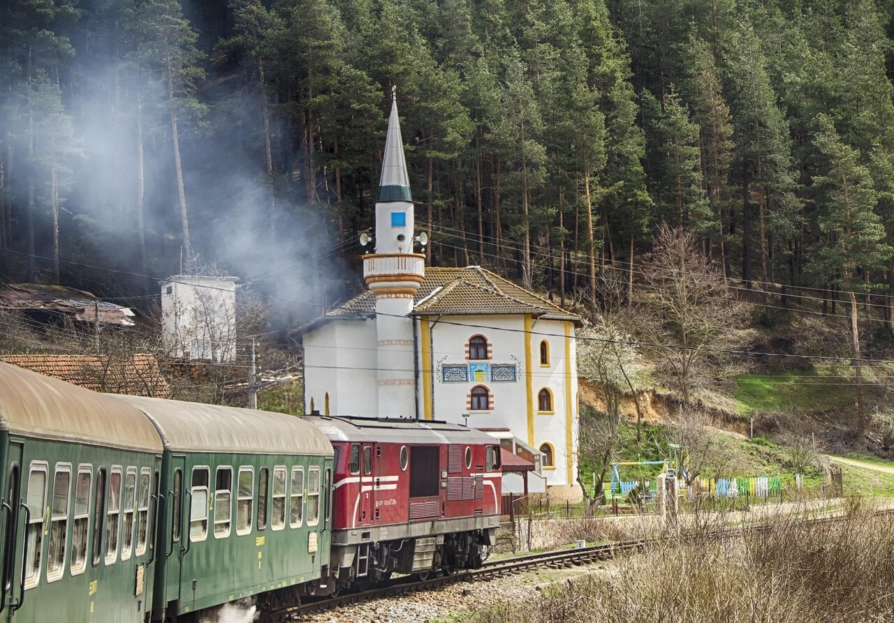 Septemvri to Dobrinishte narrow-gauge train passing through a mountain village in Bulgaria