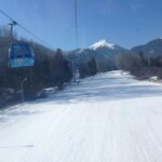Bansko gondola lift travelling above snow-covered ski slopes in the Pirin Mountains of Bulgaria.