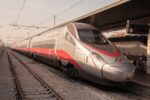 Trenitalia Frecciarossa 1000 high-speed train waiting at a station platform in Italy.