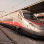 Trenitalia Frecciarossa 1000 high-speed train waiting at a station platform in Italy.