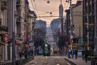 Tram travelling through central Sofia with city buildings and busy streets.