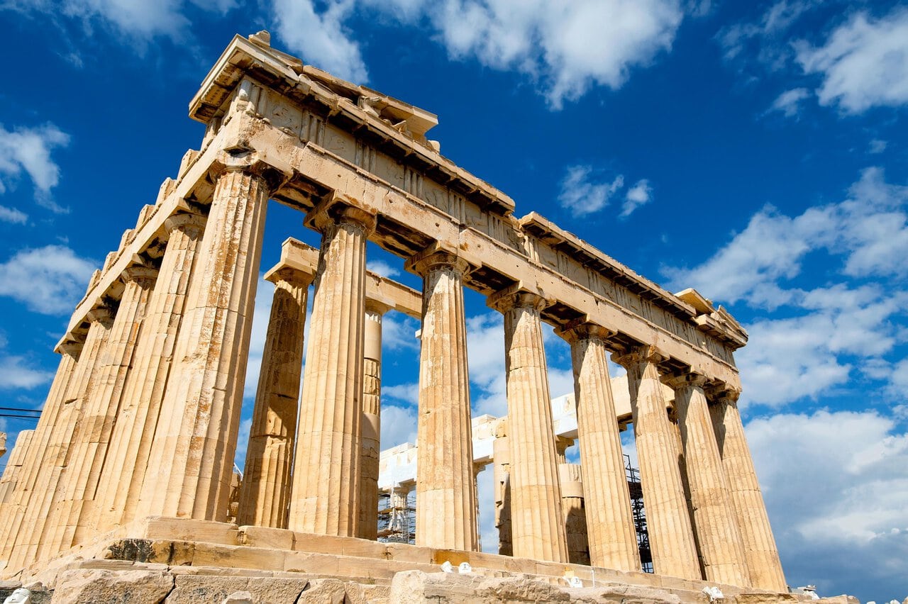 The Parthenon on the Acropolis of Athens beneath a bright blue sky.