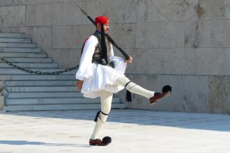An Evzone ceremonial guard marching outside the Greek Parliament in Athens.