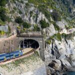 Train travelling through the dramatic coastal railway at Riomaggiore in Cinque Terre.
