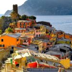 Colourful hillside houses and harbour at Vernazza in Cinque Terre during a sunny day.