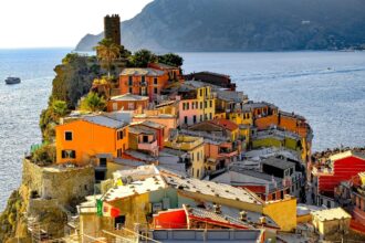 Colourful hillside houses and harbour at Vernazza in Cinque Terre during a sunny day.