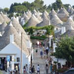 Traditional white trulli houses with conical stone roofs in Alberobello, Puglia.