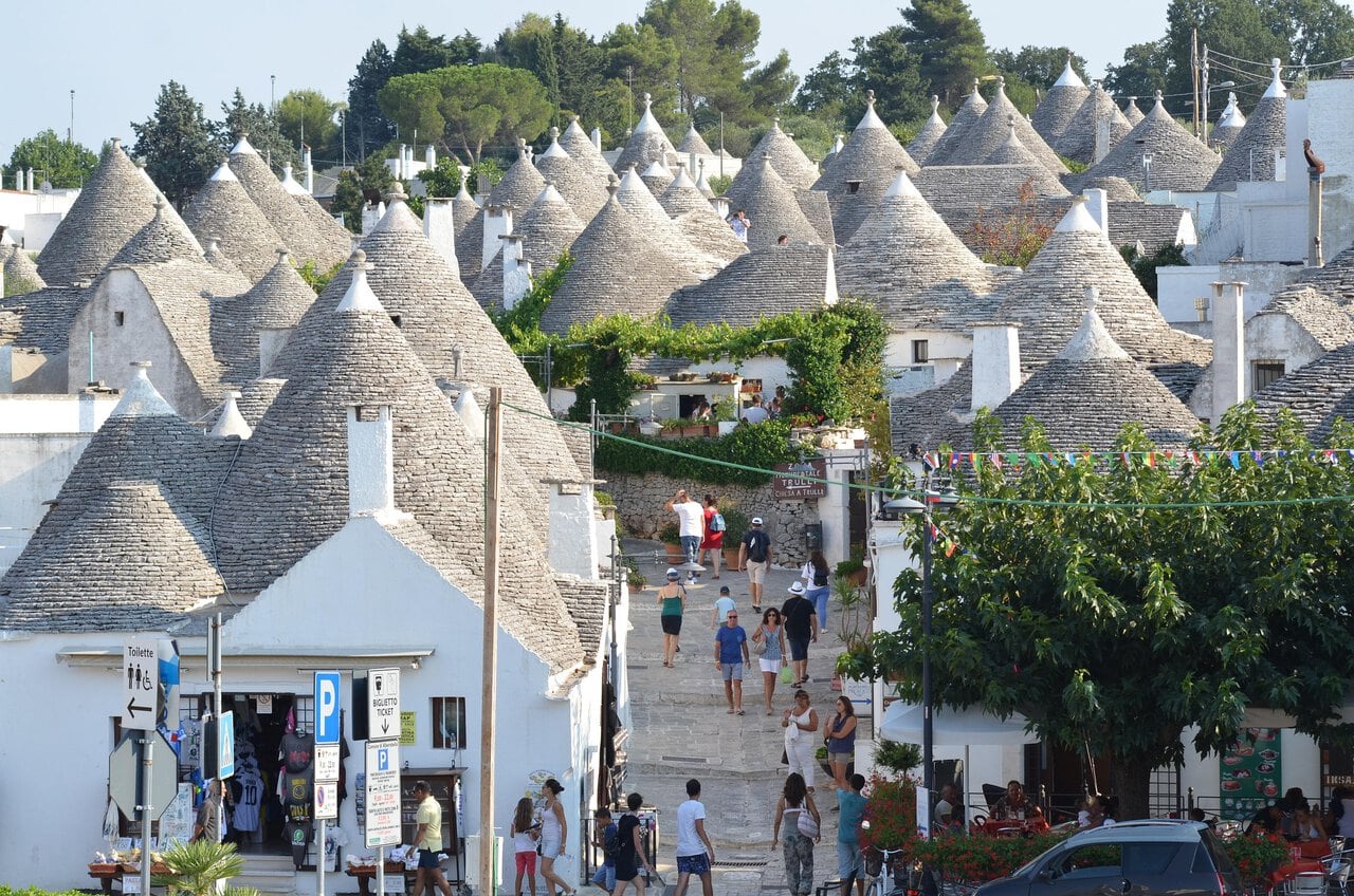 Traditional white trulli houses with conical stone roofs in Alberobello, Puglia.