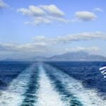 Greek flag and ferry wake on the Aegean Sea