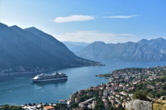 Cruise ship docked in Kotor Bay surrounded by dramatic mountains