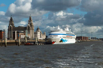 A cruise ship berthed at Liverpool Cruise Terminal beside the iconic Royal Liver Building on the River Mersey.