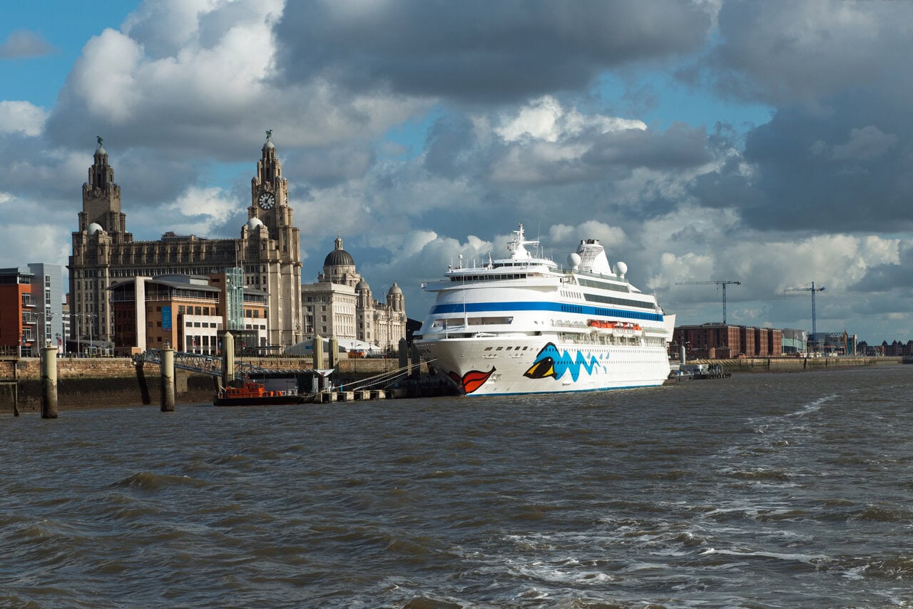 A cruise ship berthed at Liverpool Cruise Terminal beside the iconic Royal Liver Building on the River Mersey.