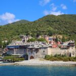 Mount Athos monastery viewed from a sightseeing cruise sailing along the Holy Mountain coastline.