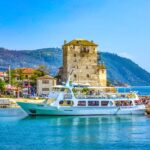 Ouranoupoli harbour with the Tower of Prosphorion and sightseeing boat in Halkidiki, Greece.