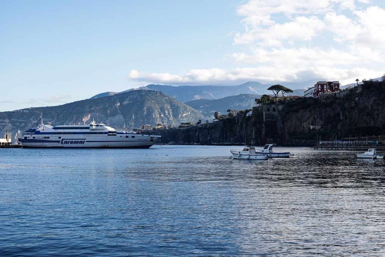 Ferry arriving at Sorrento Marina with cliffs and coastline in the background