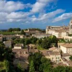 Panoramic view of Saint-Émilion's medieval town, vineyards and iconic bell tower in the Bordeaux wine region, France.