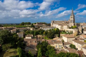 Panoramic view of Saint-Émilion's medieval town, vineyards and iconic bell tower in the Bordeaux wine region, France.