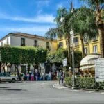 Piazza Tasso in Sorrento with cafés, palm trees and historic buildings