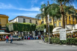 Piazza Tasso in Sorrento with cafés, palm trees and historic buildings