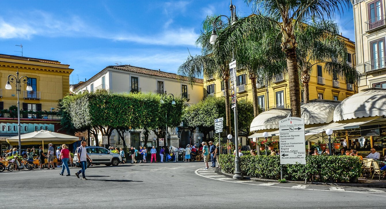 Piazza Tasso in Sorrento with cafés, palm trees and historic buildings