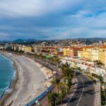 View across the Promenade des Anglais, pebble beach and colourful waterfront buildings in Nice