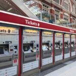 A row of railway ticket machines inside a major UK train station.