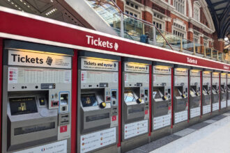 A row of railway ticket machines inside a major UK train station.