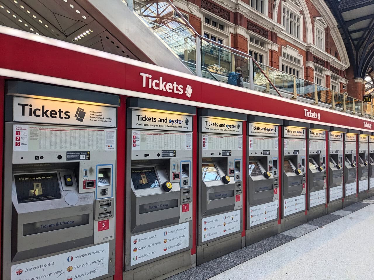 A row of railway ticket machines inside a major UK train station.
