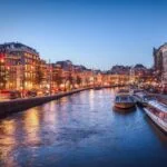 Canal cruise boats on an Amsterdam canal at dusk