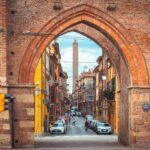Bologna street and medieval gate with Asinelli Tower in the distance
