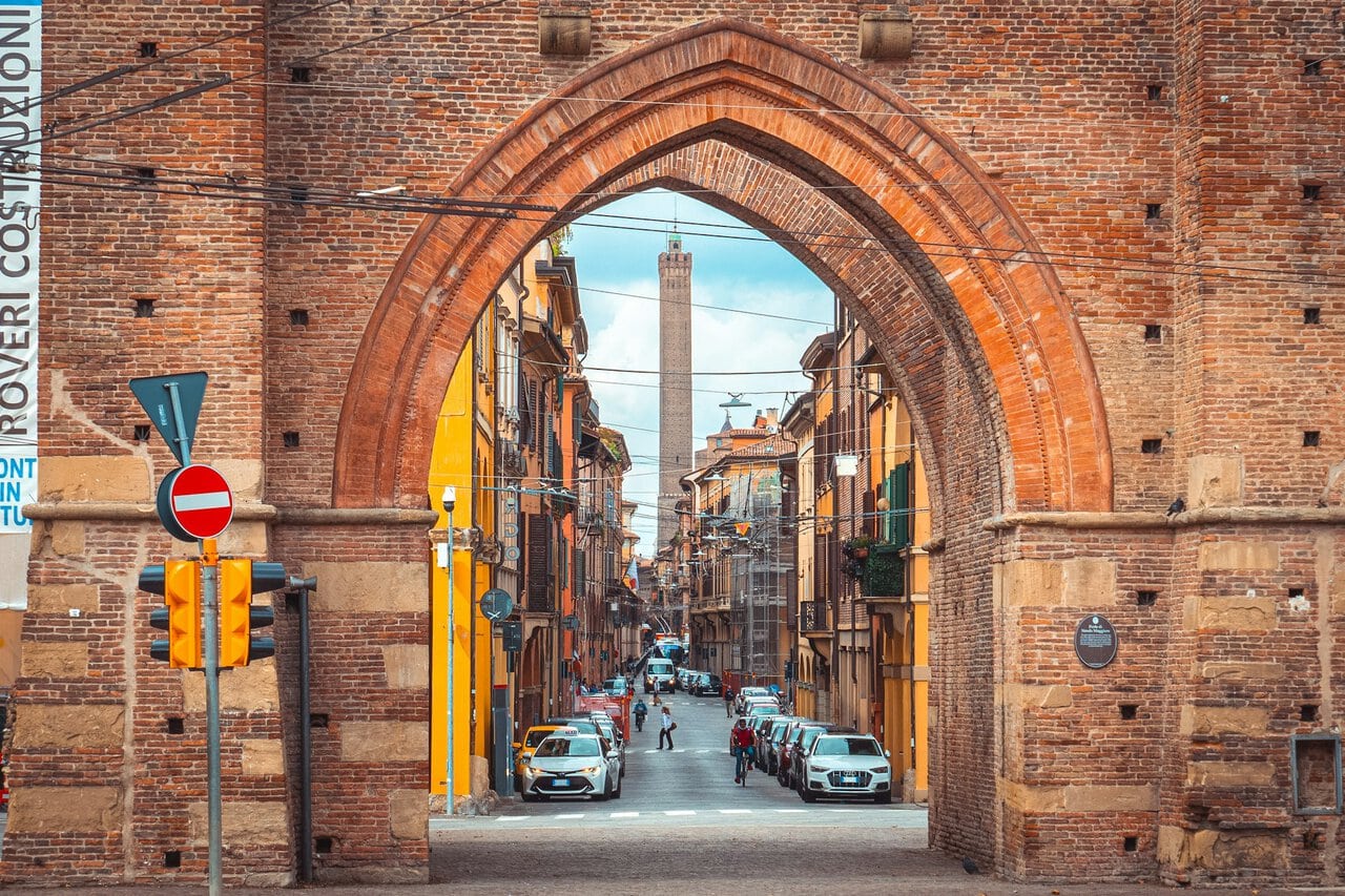 Bologna street and medieval gate with Asinelli Tower in the distance