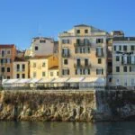 Colourful waterfront buildings in Corfu Town viewed from the sea.