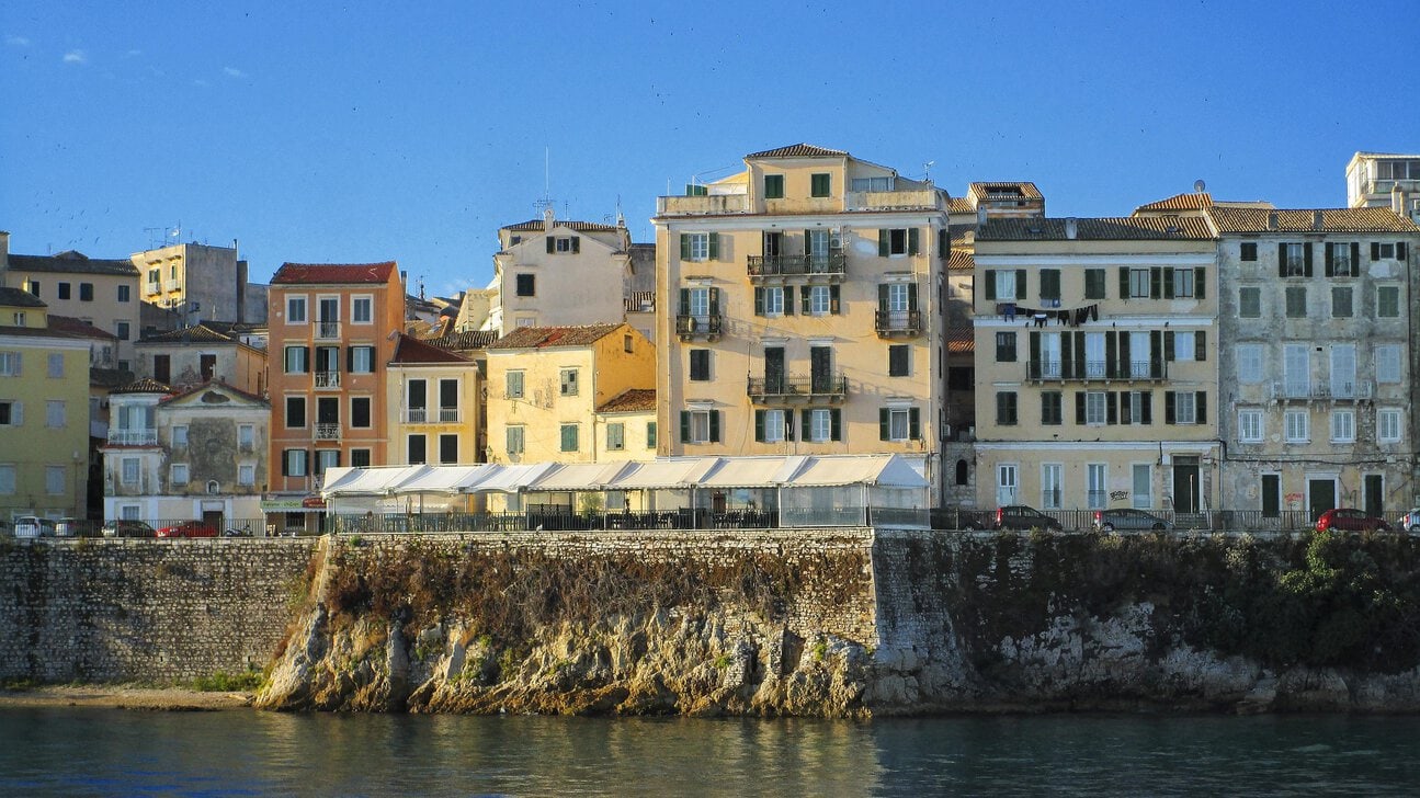 Colourful waterfront buildings in Corfu Town viewed from the sea.
