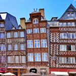 Colourful half-timbered buildings lining Place des Lices in Rennes, France.