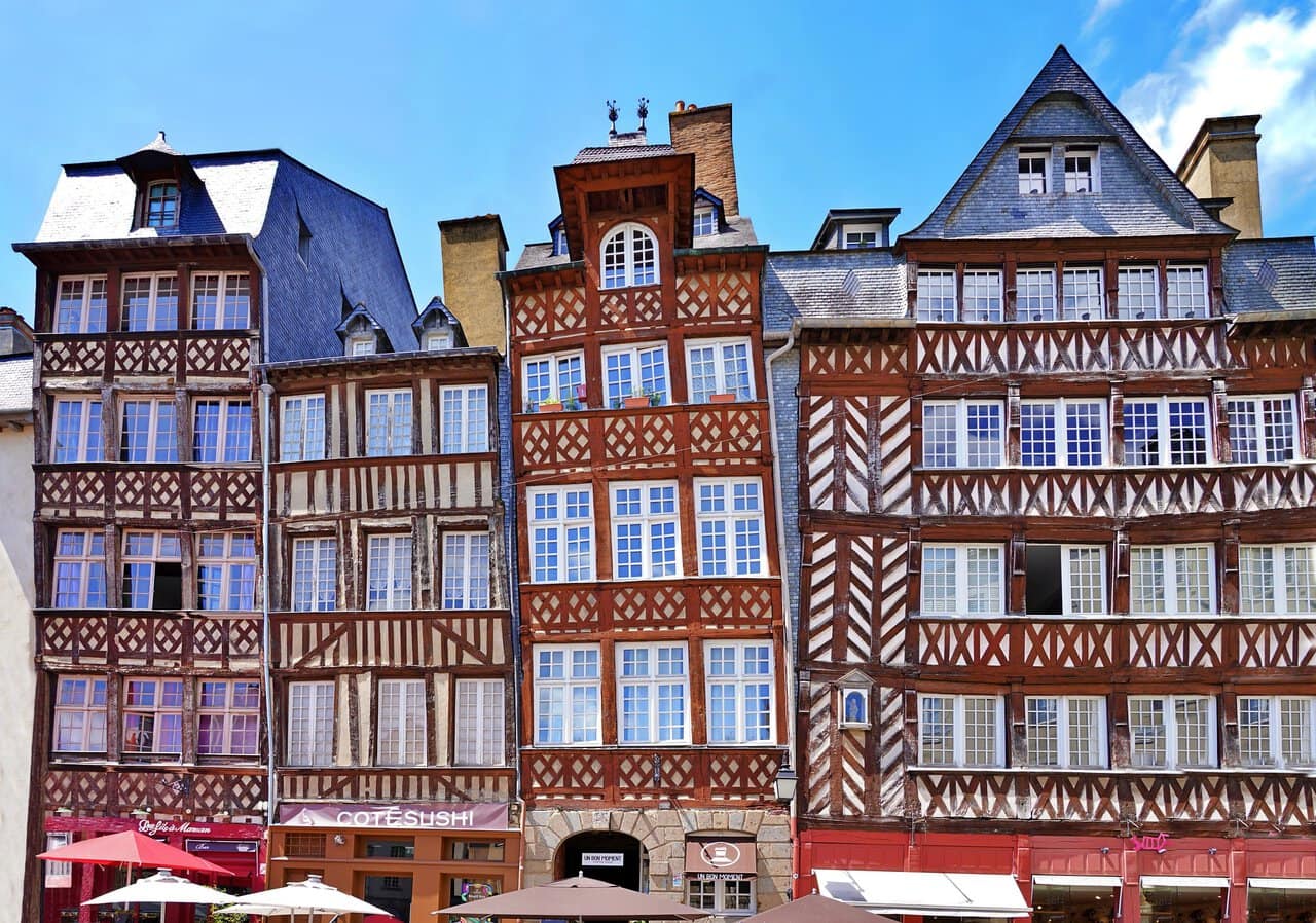 Colourful half-timbered buildings lining Place des Lices in Rennes, France.