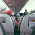 View through an aircraft cabin showing rows of passenger seats on a plane