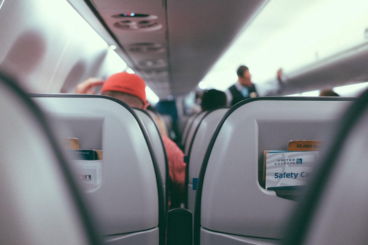 View through an aircraft cabin showing rows of passenger seats on a plane