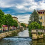 Colourful canal-side houses and antique shops reflected in the River Sorgue in L'Isle-sur-la-Sorgue, Provence