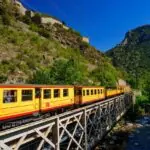 The Yellow Train crossing a bridge through the Pyrenees in southern France