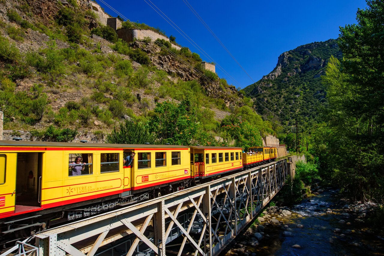 The Yellow Train crossing a bridge through the Pyrenees in southern France
