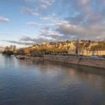 The Sarthe River and historic skyline of Le Mans at sunset, France.